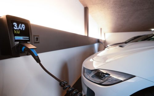 pexels photo 34800678 34800678 White electric car charging at indoor station, emphasizing sustainability and efficiency.